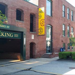 A view of a brick building featuring a parking entrance and colorful signage.
