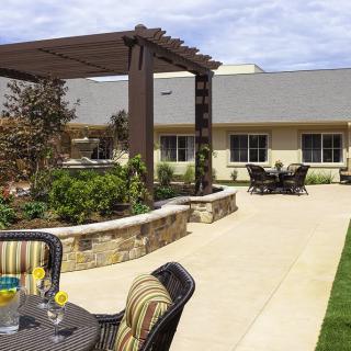 A well-designed outdoor patio area with a pergola, garden landscaping, and comfortable seating for relaxation.