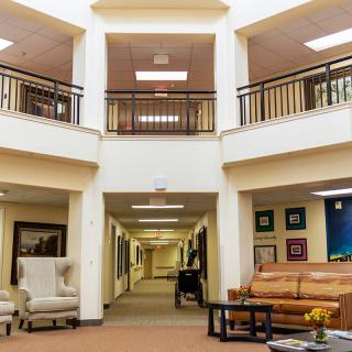 A spacious lobby with comfortable seating and a hallway leading to various rooms.