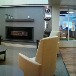A cozy waiting area featuring modern furniture and a stylish fireplace.