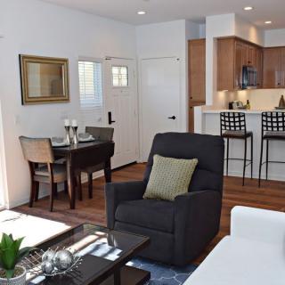 A modern open-concept living space featuring a cozy living room, dining area, and kitchen with an elegant design.
