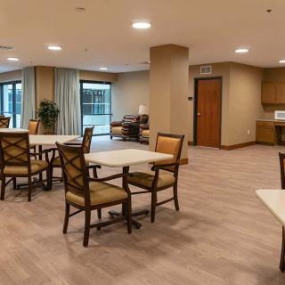 A modern dining area with tables and chairs, featuring wood flooring and ample seating.