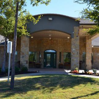 The welcoming entrance of a modern building surrounded by greenery.