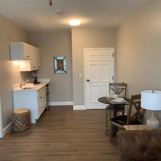 A cozy studio apartment with a compact kitchenette and comfortable furniture.