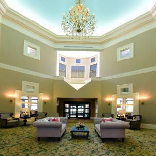 An elegant lobby with a luxurious chandelier and comfortable seating arrangements.