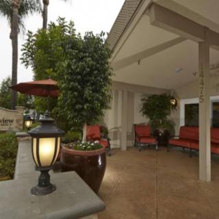A cozy outdoor patio with comfortable seating, decorative lanterns, and lush plants.