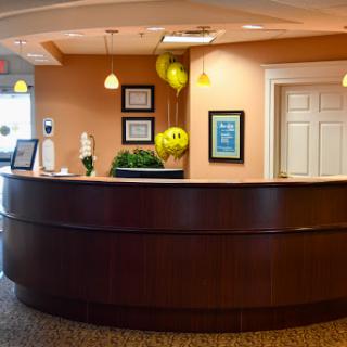 A warm and inviting reception area featuring a sleek front desk, vibrant decorations, and a welcoming atmosphere.