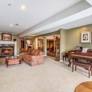 A cozy living room featuring a fireplace, piano, and comfortable seating arrangements.