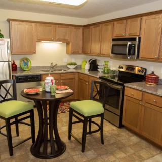 Modern kitchen with wooden cabinets and a compact dining set.