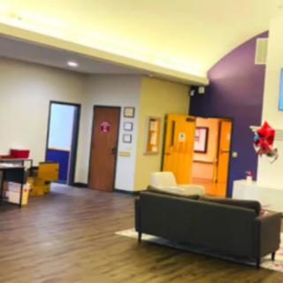 A well-lit office lobby with a couch and decorations on the wall.