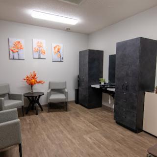 A modern waiting room featuring stylish furniture and vibrant artwork.