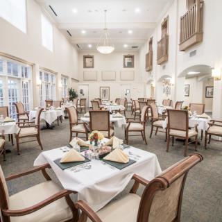 An elegant dining room with neatly arranged tables and chairs, featuring a bright and spacious interior.