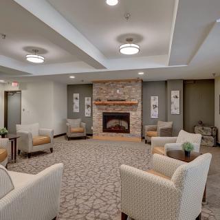 A modern living room with comfortable seating and a central fireplace.