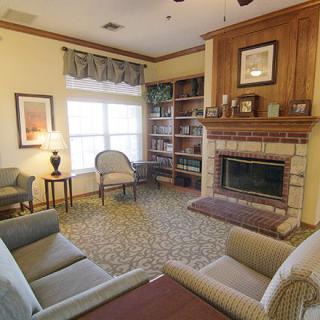 A cozy living room featuring a fireplace and a well-organized bookshelf.