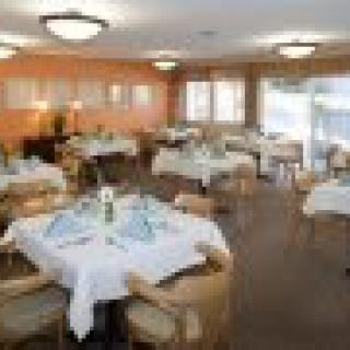 An elegantly set dining room with neatly arranged tables and chairs.