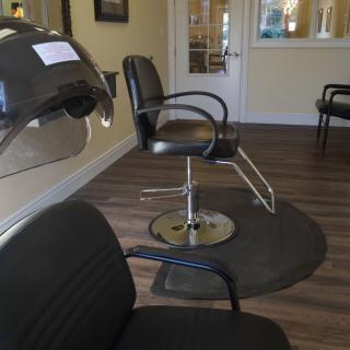 An empty hair salon with chairs and a hair dryer.
