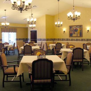 A well-decorated dining room with multiple tables and chandeliers.