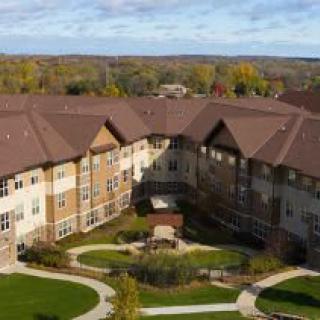 Aerial view of a large building surrounded by landscaped gardens.