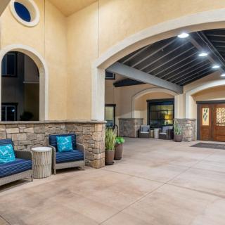 A well-lit entrance with outdoor seating and a covered walkway.
