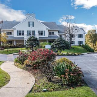 A beautiful residential building surrounded by landscaped gardens and a pathway.