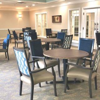A well-lit dining area featuring multiple tables and chairs.