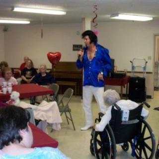 A performer entertains an audience at a nursing home.