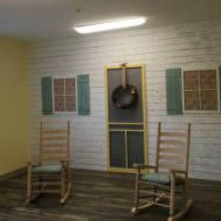 A cozy interior with two rocking chairs and wall art featuring a hanging pan.
