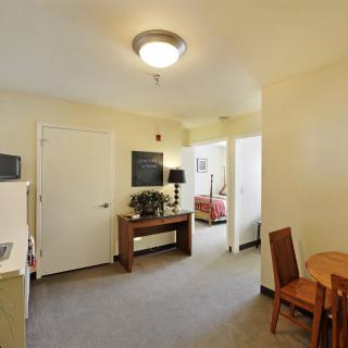 A view of a cozy apartment interior with a dining area and visible bedroom.