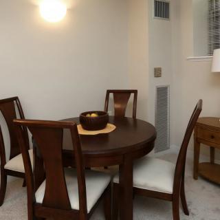 A cozy dining area featuring a round wooden table with four chairs.
