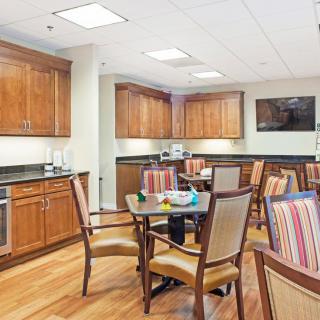 A modern kitchen and dining area with wooden cabinets and striped upholstered chairs.