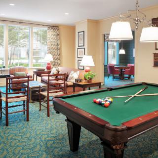 A cozy recreation room featuring a pool table and comfortable seating.
