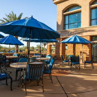 A tranquil outdoor patio area featuring blue umbrellas and comfortable seating.