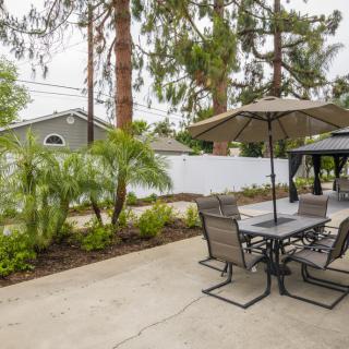 A well-maintained backyard patio with outdoor furniture and landscaping.