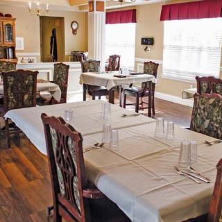 A cozy dining room with neatly arranged tables and chairs.