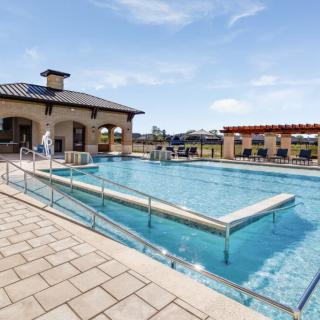 A spacious outdoor swimming pool area with surrounding architectural structures.
