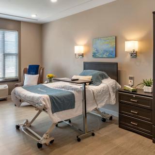 A well-furnished hospital room with a bed and medical equipment.