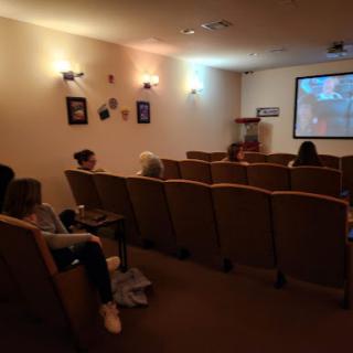 A small audience enjoying a movie in a cozy screening room.