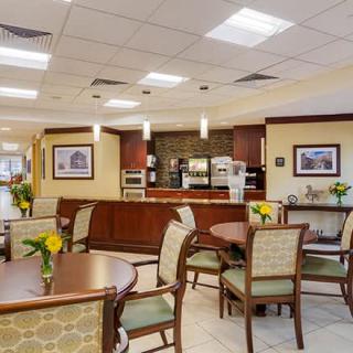 A cozy indoor cafe seating area with tables and chairs, decorated with flowers.