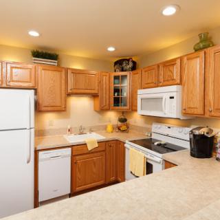 A cozy and modern kitchen featuring wooden cabinets and essential appliances.