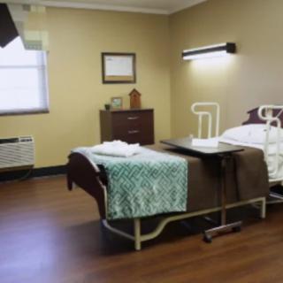 A clean and organized hospital room with a single bed and medical equipment.