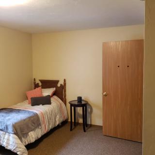 A minimalist bedroom with a single bed and a small table.