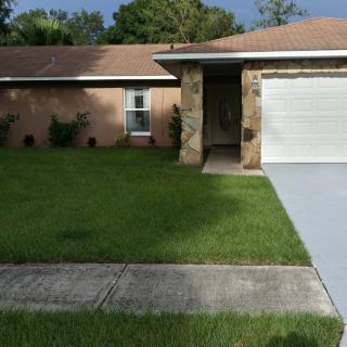 A suburban house with a well-maintained lawn and driveway.