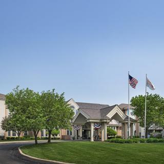 A building with flags and well-maintained landscaping on a clear day.