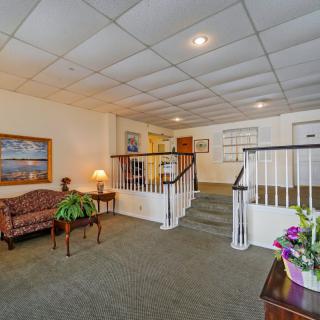 A cozy interior lobby featuring a staircase, seating area, and decorative elements.