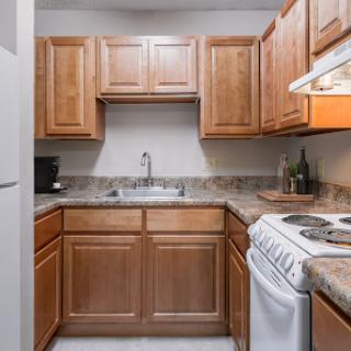 A compact kitchen featuring wooden cabinets and essential appliances.