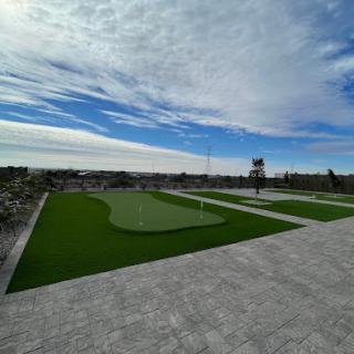 A serene outdoor recreation area featuring a well-maintained golf green under a partly cloudy sky.