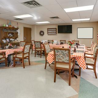 A cozy dining room with checkered tablecloths and wooden chairs.