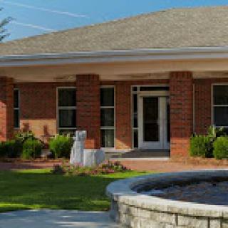 A view of a well-maintained brick building with a welcoming front entrance and landscaped surroundings.
