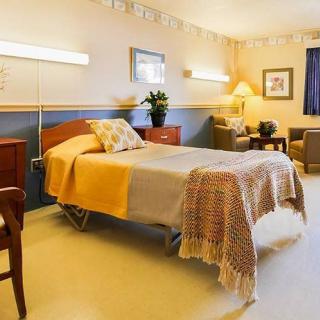 A well-equipped and comfortable hospital room with a single bed and cozy furnishings.