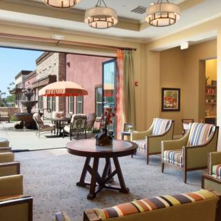 A modern lounge area opens up to a spacious patio with comfortable seating arrangements.